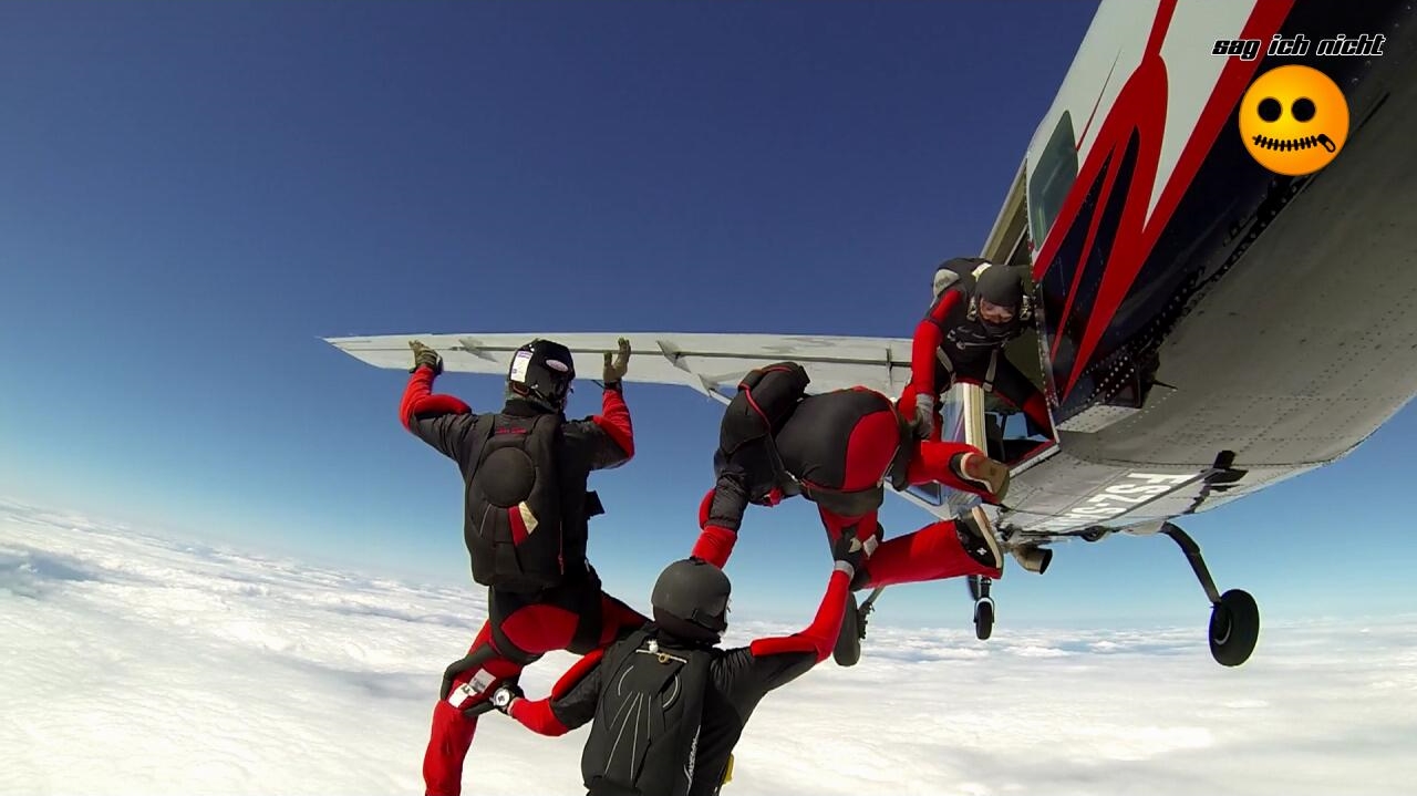 Vierer-Team beim Exit aus der Absetzmaschine über einem Wolkenmeer